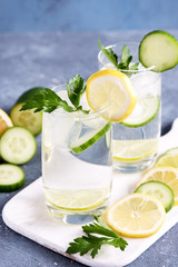 Close up glass of detox water with cucumber lemon and lime Cold drink Cold lemonad with vegetables and citrus fruits