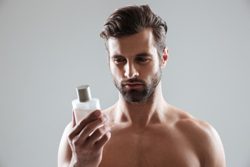 Man gazing at bottle of perfume isolated