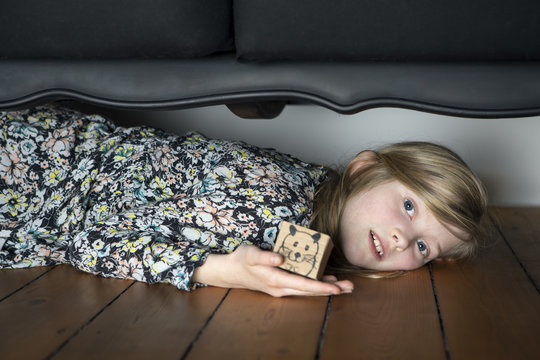 Girl lying on floor holding box with painted mouse