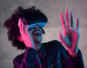 Woman in virtual reality goggles touching air