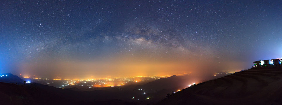 Panorama Milky way galaxy and city light at Phutabberk Phetchabun in Thailand.Long exposure photograph.With grain