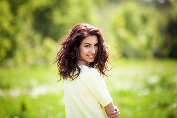 Woman smiling with perfect smile and white teeth in a park and looking at camera