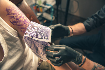 Maker taking away paper picture from client arm