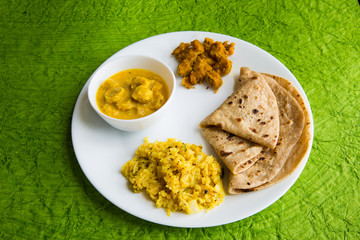 Traditional rajasthani meal - chapati,besan gatte and khichdi clicked in available light on green background