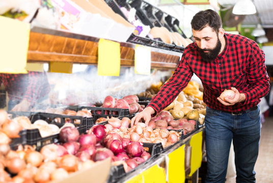  Shop assistant holding onions in grocery shop
