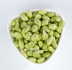 green soybeans in a bamboo basket isolated on white background
