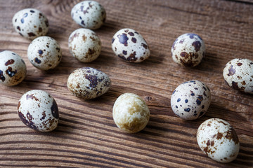 Sprinkled quail eggs on a wooden table