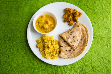 Traditional rajasthani meal - chapati,besan gatte and khichdi clicked in available light on green background