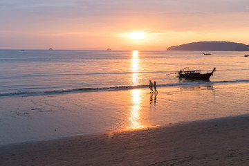 Fototapeta na wymiar Couple Walking Holding Hands On Beach At Sunset In Thailand, Young Tourist Man And Woman On Sea Holiday While Asia Summer Vacation