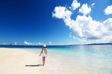 南国沖縄の美しいビーチで寛ぐ女性

