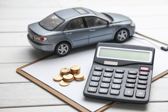 car model,caculator and coins on white table