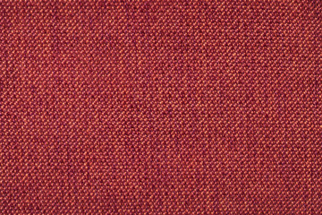 Red background from woolen texture textile, closeup. Structure of the wicker fabric macro.