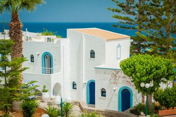 Greek architecture - white buildings, sea and blue windows, Bougainvillea on the white wall