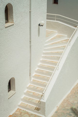Greek architecture - white buildings, sea and blue windows, stairs