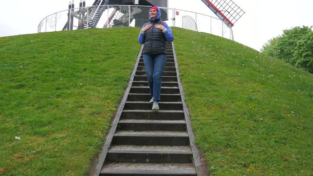 A woman traveler comes down the stairs.