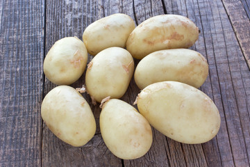 Young potatoes on wooden background