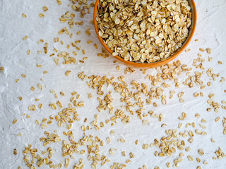 Dry rolled oatmeal in bowl on white background. Top view. space for text
