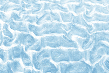 Natural ocean beach sand texture background. Wet sand background with wavy pattern after the tide in light blue color. Close up horizontal composition.