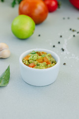Traditional mexican avocado - vegetarian dip surrounded by its ingredients.