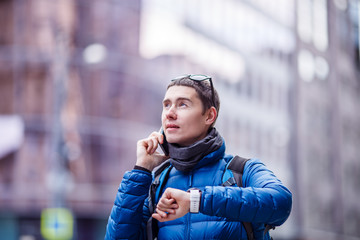Fototapeta premium Man talking on phone and looking at smartwatch