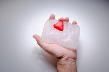 Masculine hand holds a heart of ice