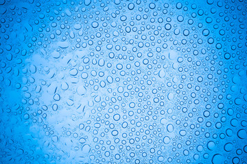 Rain droplets on blue glass background, Water drops on glass.