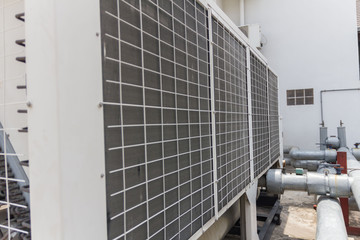 The technician is repairing the electrical system. Industrial air conditioning units. A plurality of cooling units installed in the wall of a building.