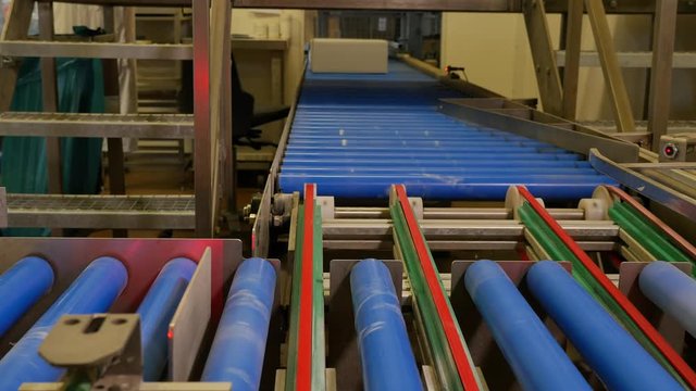 Boxes traveling and rolling on the conveyor belt of a bakery factory