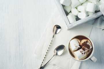 White coffee Cup and marshmallows in a wooden box over a white background