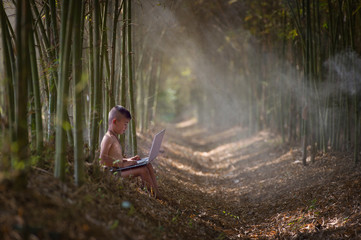 The boy studying by online learning with laptop at outdoor, countryside of Thailand