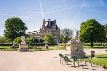 View of the Tuileries garden in Paris by a sunny morning with the statues of the Good Samaritan and Alexander Fighting in the foreground and the Flore pavilion of the Louvre palace in the background - obrazy, fototapety, plakaty