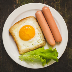 breakfast. Fried eggs in bread, sausages, lettuce and greens.