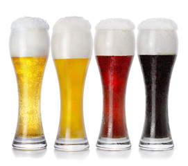 Four glasses of different fresh foamy beer