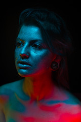portrait of beautiful young woman with blue studio light