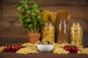 Dry pasta with ingredients on a old wood