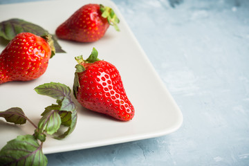 Fresh ripe strawberry on the rustic background. Shallow depth of field.