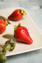 Fresh ripe strawberry on the rustic background. Shallow depth of field.