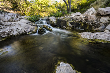 small cascading waterfall and stream in a natural park area