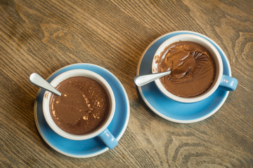 Blue Cups of hot Chocolate drink on dark wooden background. Morning time. Lover concept