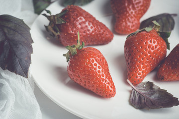 Fresh ripe strawberry on the rustic background. Shallow depth of field. Toned image.
