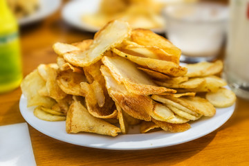 Plate with fresh fried golden potato chips restaurant on the beach. Concept Summer.