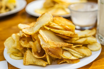 Plate with fresh fried golden potato chips restaurant on the beach. Concept Summer.