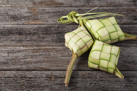 Ketupat (Rice Dumpling) On Wood Background. Ketupat is a natural rice casing made from young coconut leaves for cooking rice during eid Mubarak