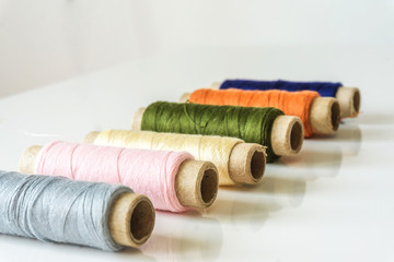 Close-up of a sewing set. Spool with thread in different colors.Soft defocus in depth. Copy space.