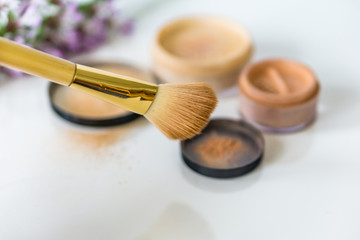 Close-up of mineral, powder, foundation makeup and brush to apply the product. 