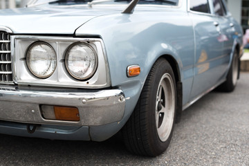 Blue pastel car with the circle headlight in selective focus.