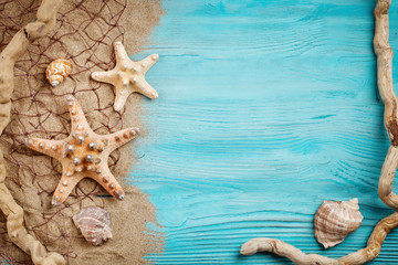 Starfish, pebbles and shells lying on a blue wooden background . There is a place for labels.