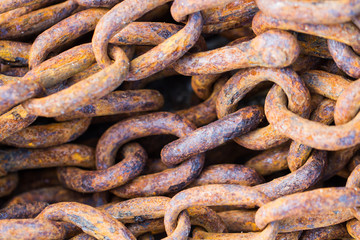 Fototapeta premium A full frame image of thick, heavy industrial chains that are rusty, weather and worn an industry background image.