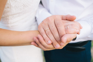 lovers holding hands with gold wedding rings, the bride and groom