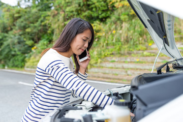 Woman calling others with repairing the car